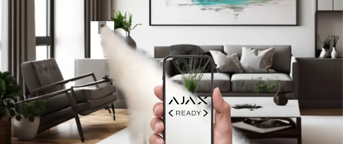 Un ambiente domestico in cui un generatore nebbiogeno Concept eroga nebbia, con in primo piano un telefono che mostra la schermata Ajax Ready.